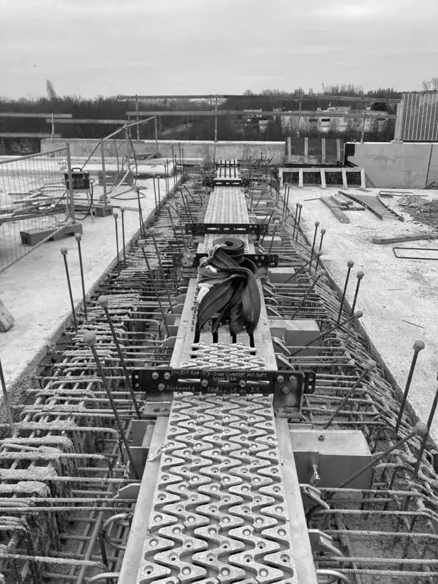 Detail van een brugvoegconstructie op een bouwsite, met wapening, metalen afstandhouders en bekisting voor infrastructuurwerken en betonherstelling