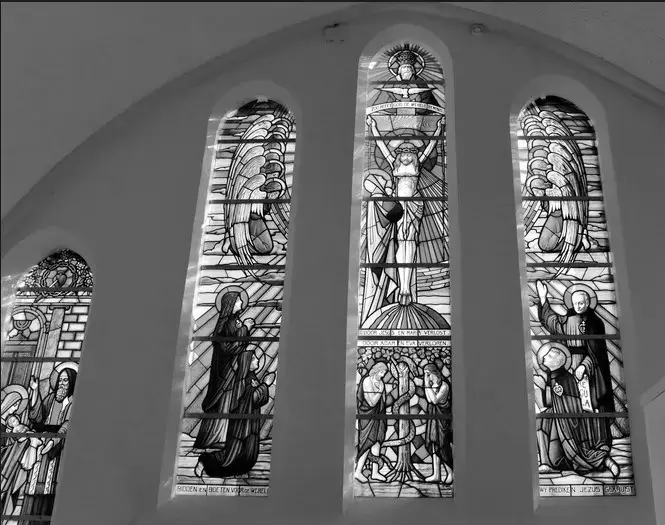 Historisch glas-in-loodraam met religieuze taferelen en gedetailleerde figuratieve voorstellingen, onderdeel van een restauratie‑ en erfgoedproject in een monumentaal kerkinterieur.