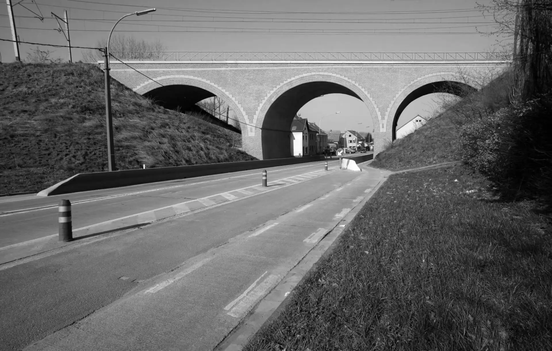 Betonnen brugkolom onder een viaduct met meerdere herstelde en bijgewerkte zones in verschillende vormen en structuren, zichtbaar na betonreparatie‑ en oppervlakherstelwerken.