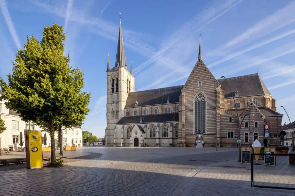Sint-Amandskerk in Geel met karakteristieke kerktoren en bakstenen gevels, gefotografeerd vanaf het plein.