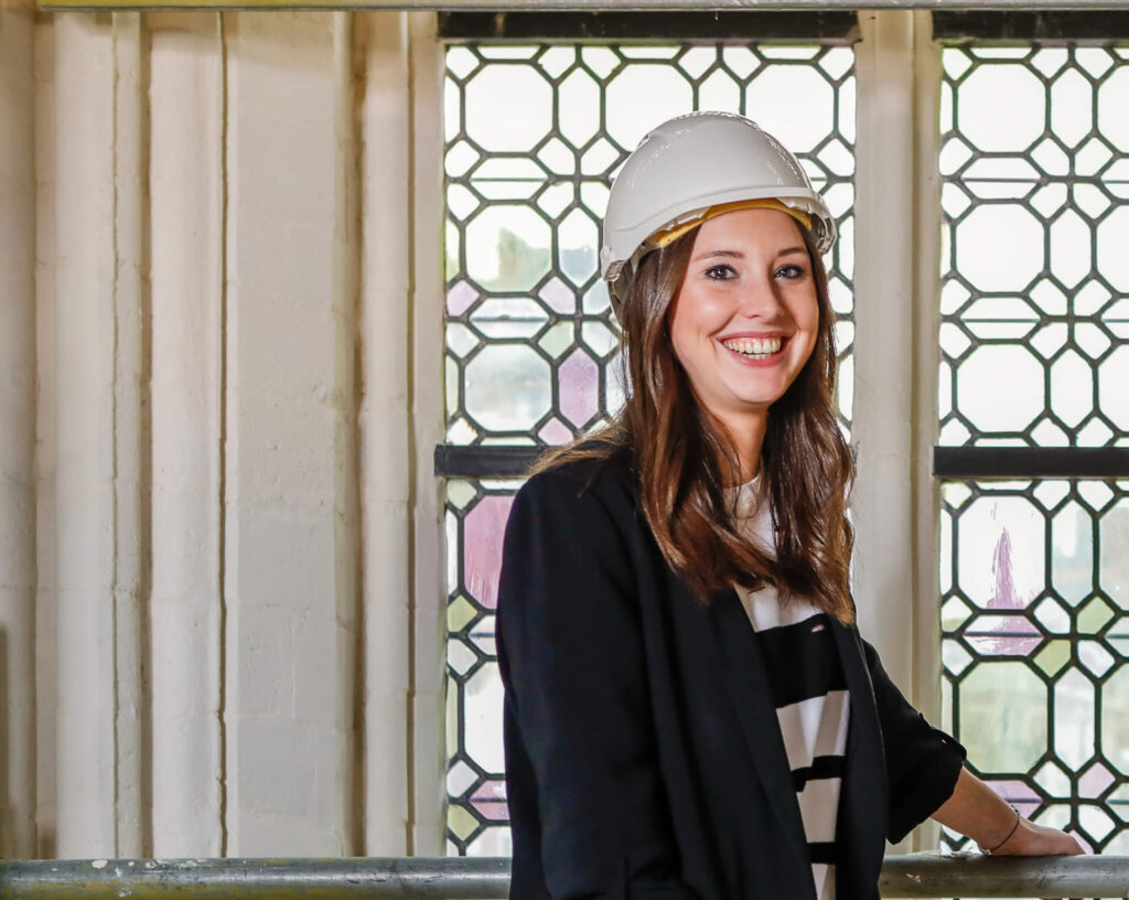 Renotec medewerker met veiligheidshelm in historisch interieur met glas-in-loodramen