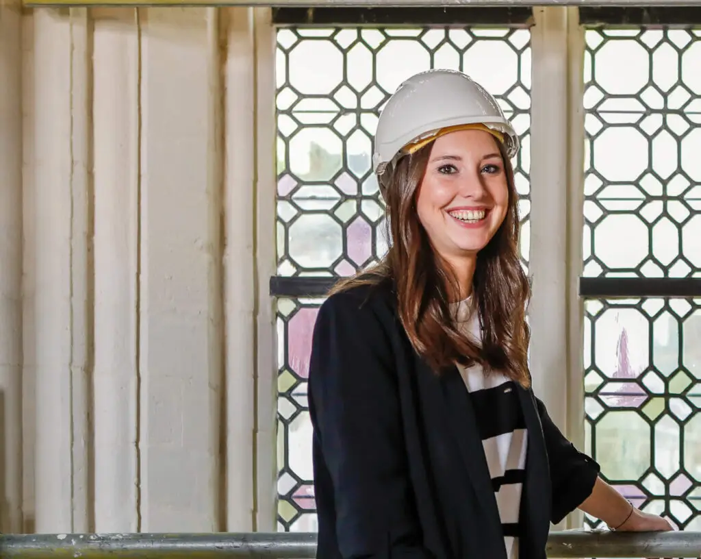 Renotec medewerker met veiligheidshelm in historisch interieur met glas-in-loodramen