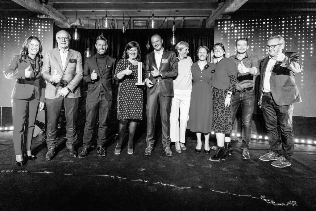 Uitreiking van Voka Prijs Duurzaam Ondernemen aan Renotec met team en trofee op podium